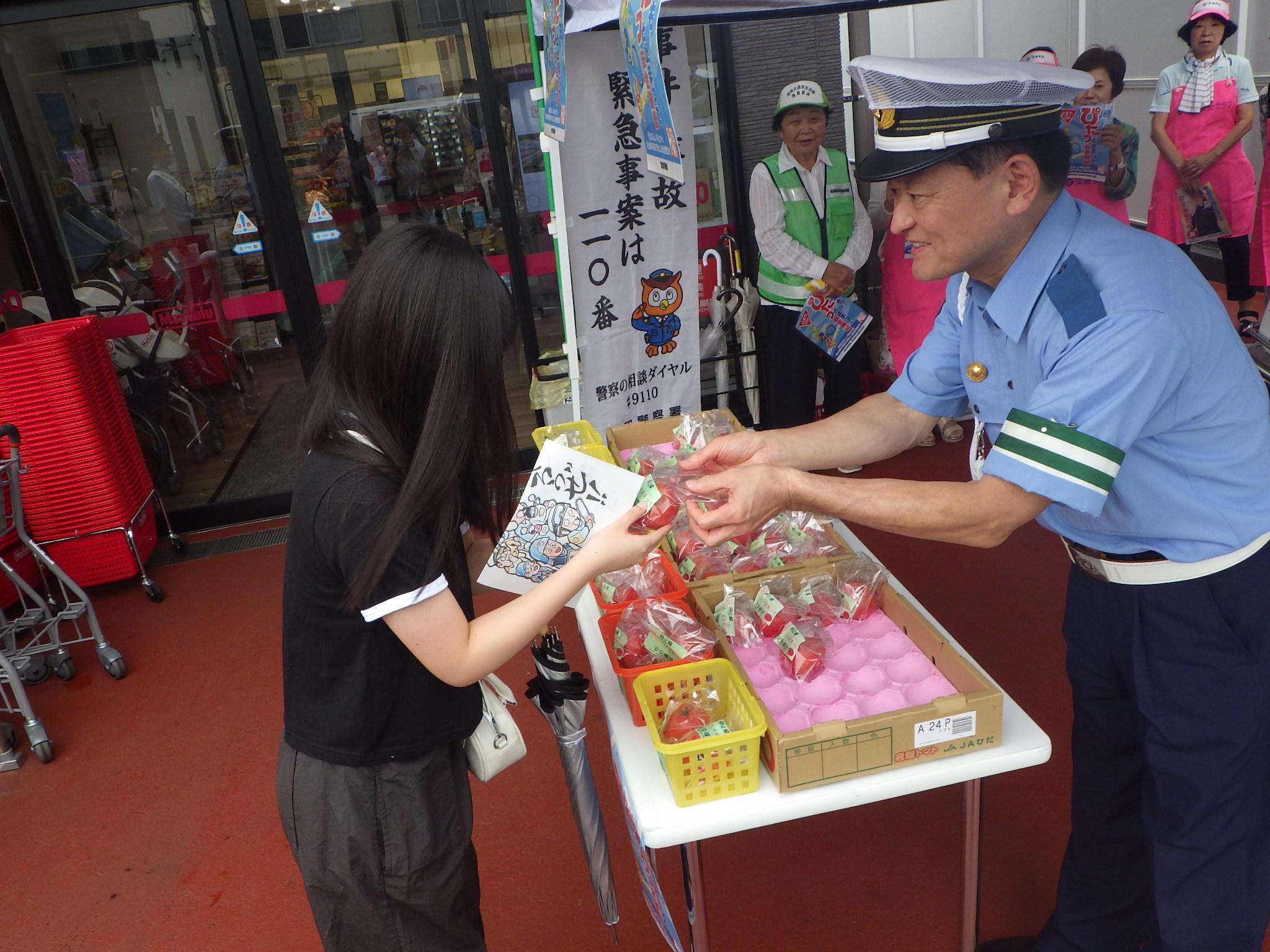 昭和署長からトマトを受け取る市民の方