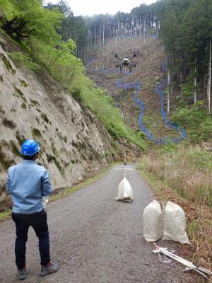 ドローンの操縦者と飛び立つドローン