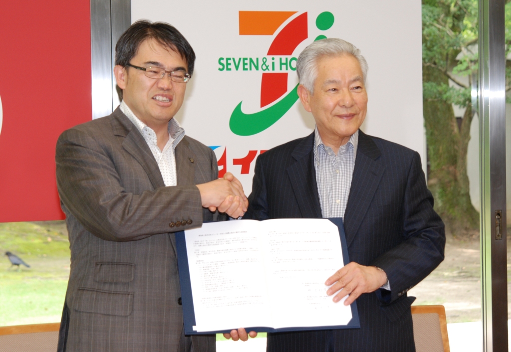 (協定を締結し握手する亀井社長・大村知事)