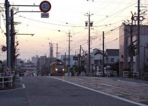 夕焼けを背に石畳をのぼる路面電車